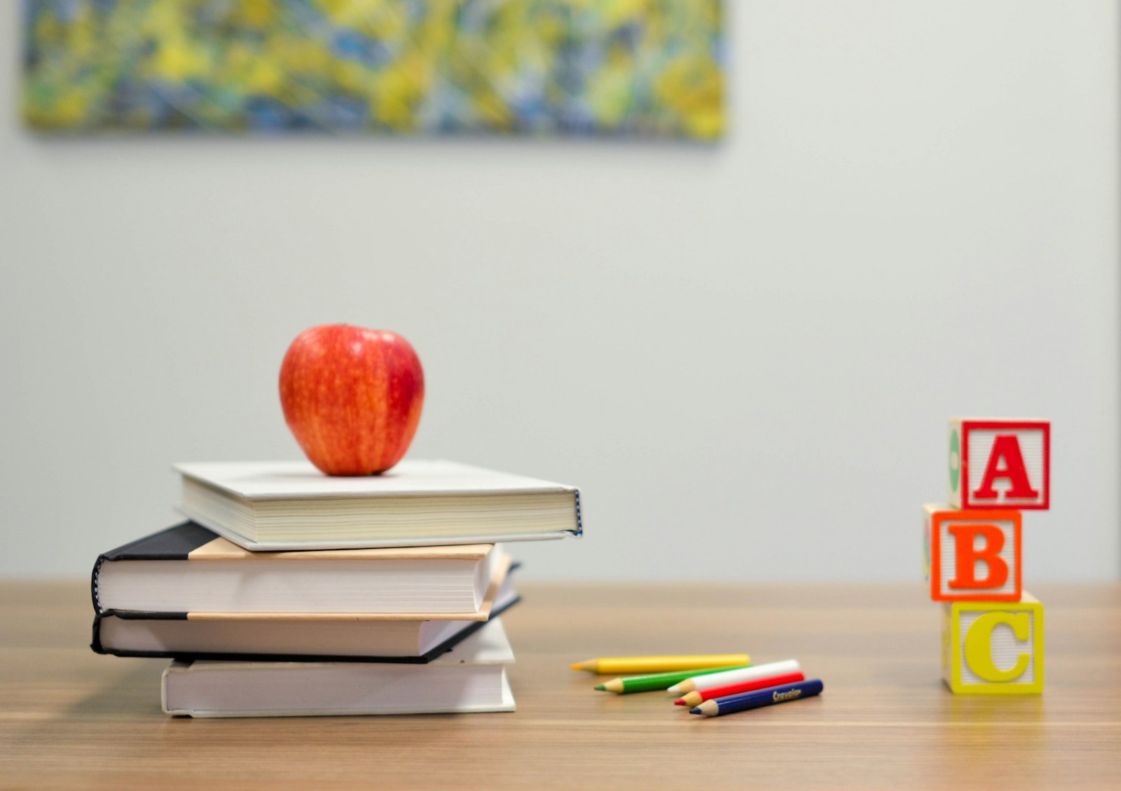 Apple on a stack of books beside alphabet blocks