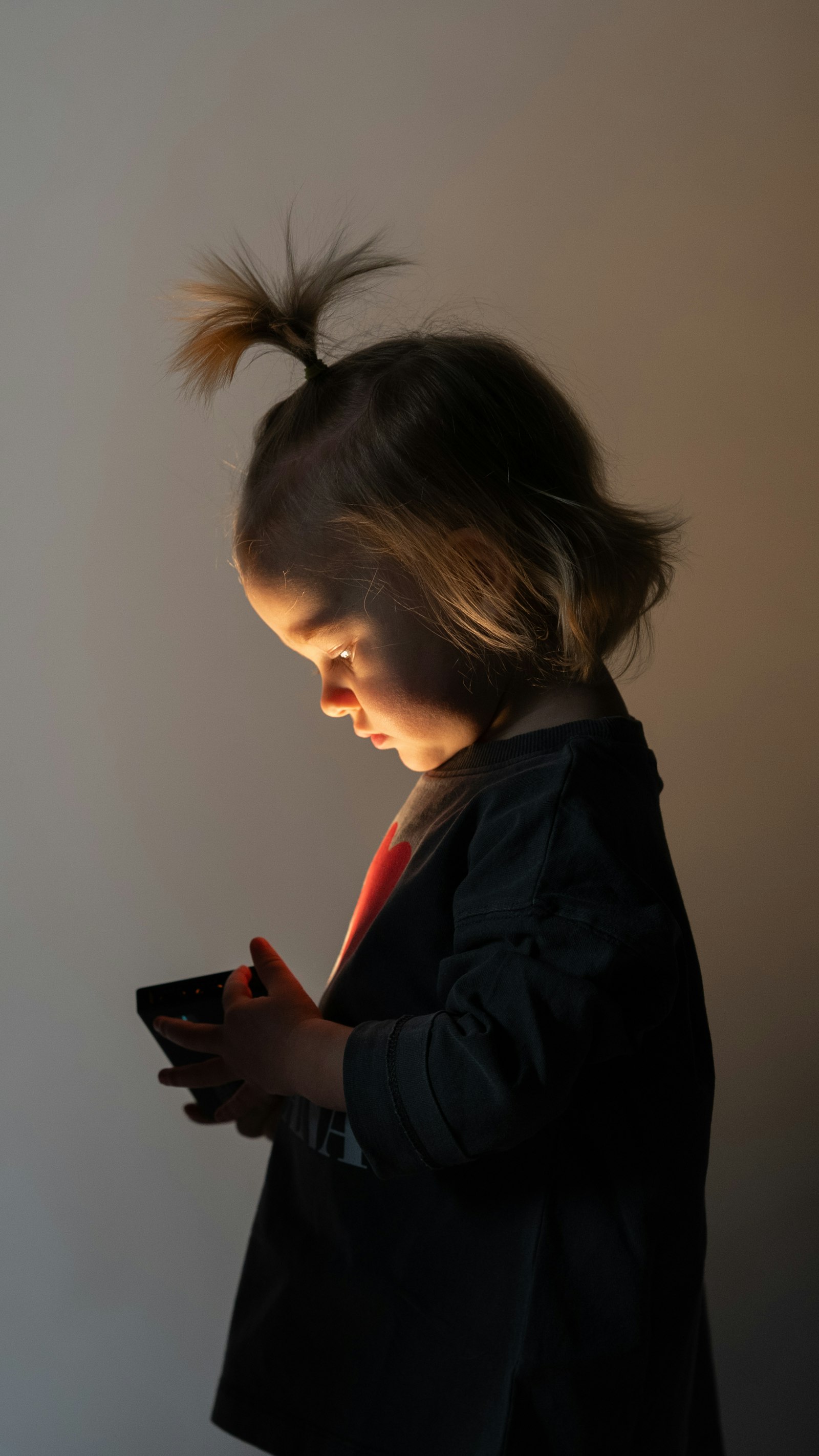 Young child absorbed in a glowing phone screen